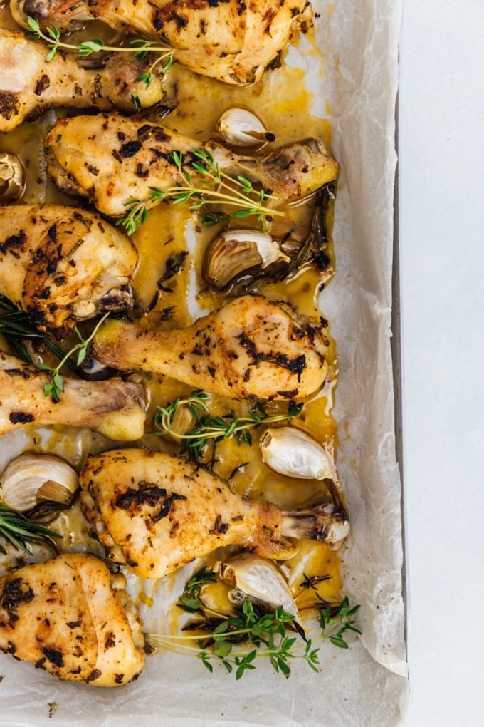 These are the best oven baked chicken legs! No need to wait for the marinade. Yummy, juicy and easy to make. #chickenrecipe #bakedchicken #chickenlegs #chickendrumsticks 用烤箱烤鸡腿,加入蒜瓣、迷迭香和新鲜百里香,放在烤盘上