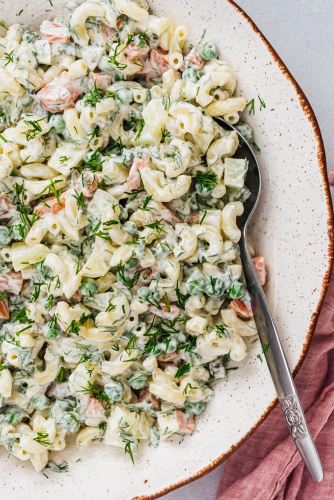Turkish Macaroni Salad with vegetables, pickles and pasta. With a light and tangy mayo-yogurt dressing. It carries your picnics, potlucks and parties to perfection. #pastasalad #macaronisalad #vegetarianpastasalad #pastasaladdressing 经典的通心粉沙拉配酸奶,蛋黄酱,豌豆,胡萝卜,新鲜的莳萝,土豆放在陶瓷碗里