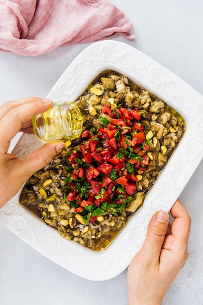 Turkish Eggplant Salad is the yummiest summer lunch when combined with a tangy dressing and topped with fresh summer tomatoes. #eggplantrecipe #eggplant #roastedeggplant #turkishsalad #turkishrecipe 在烤茄子沙拉上淋上橄榄油