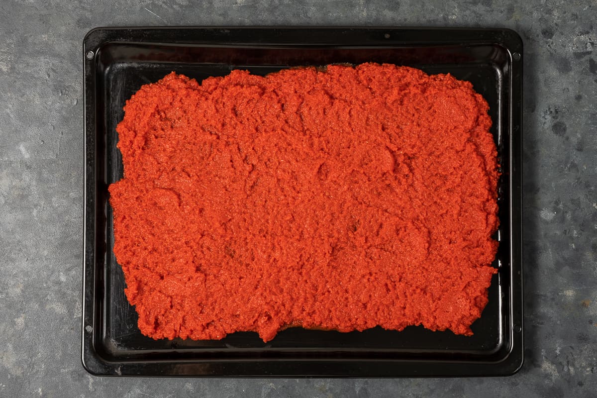 将过滤好的番茄泥放在黑色烤盘上。