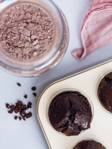 从俯视图拍摄，巧克力蛋糕混合物在一个罐子里，巧克力松饼在松饼盘里。