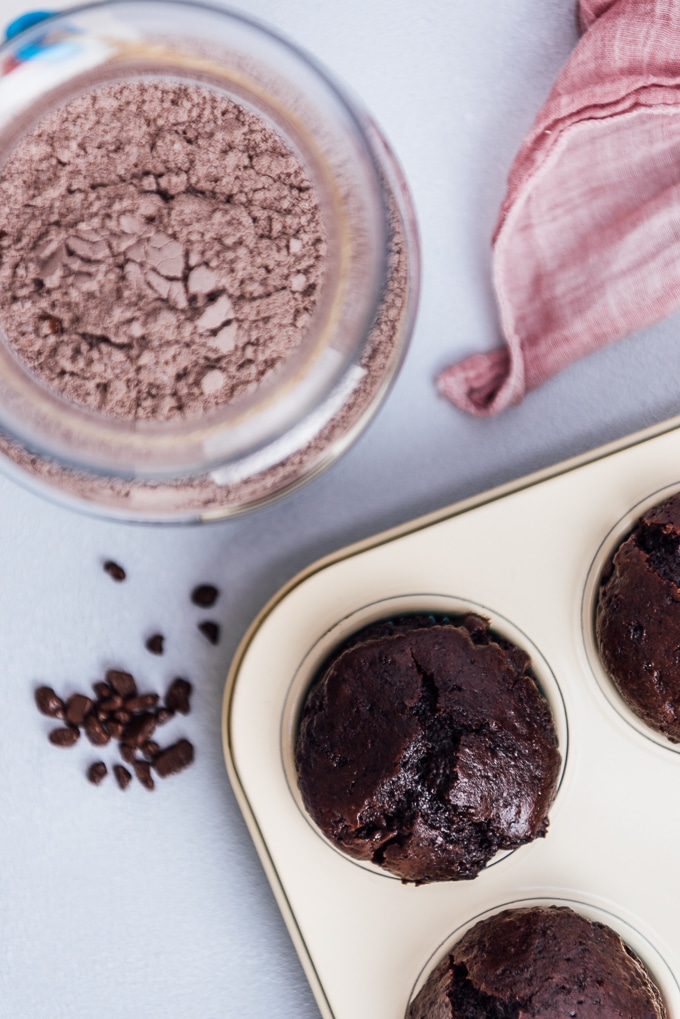 罐子里的巧克力蛋糕粉和松饼盘里的巧克力松饼从俯视图拍摄。