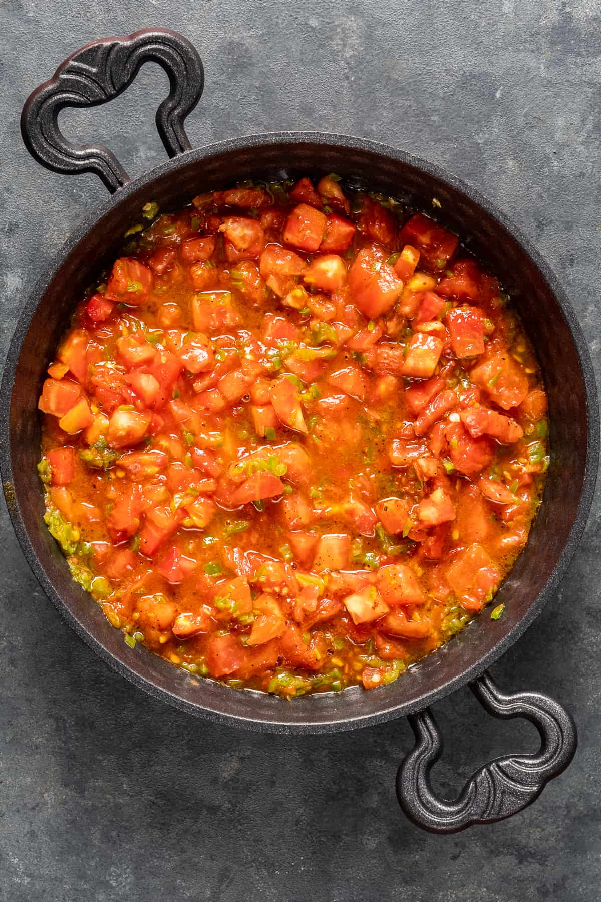 番茄丁和青椒在平底锅中烹饪