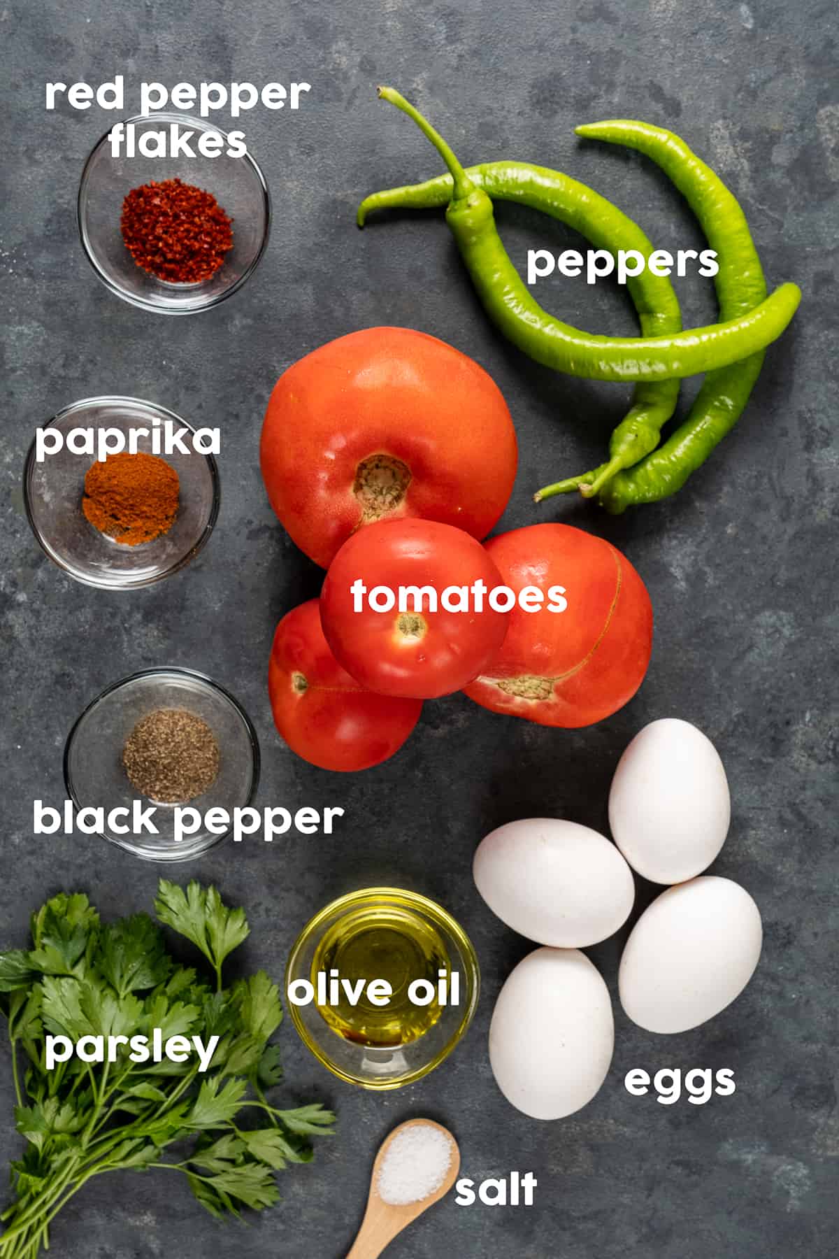 西红柿，土耳其青椒，带壳的鸡蛋，香料，欧芹和橄榄油，深色背景。