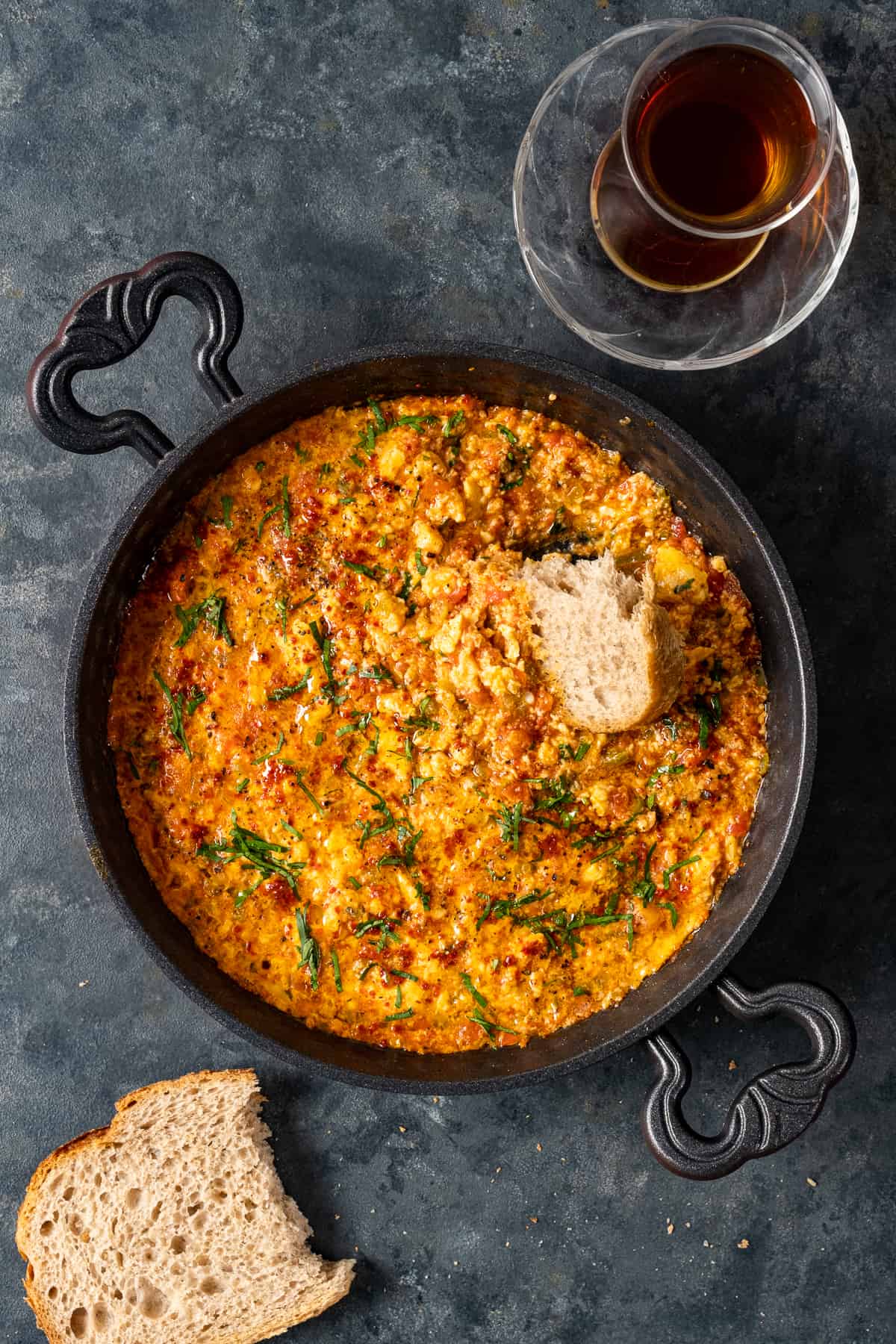 西红柿和辣椒炒鸡蛋,又名menemen,放在平底锅里,配上一杯土耳其茶和面包片。