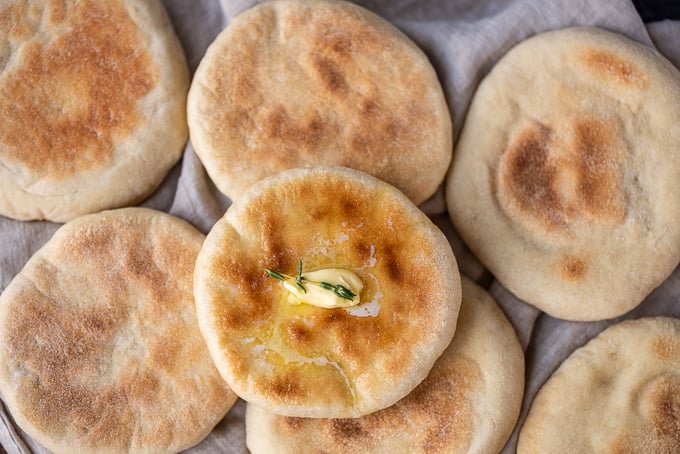 一堆土耳其面饼，叫做巴兹拉玛，上面涂着黄油和百里香，放在亚麻布上。