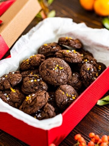 巧克力果仁巧克力曲奇饼用橙色zest和海盐在一个红色礼物盒。