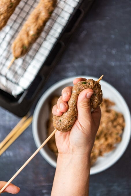 用手在木串上烤牛肉串