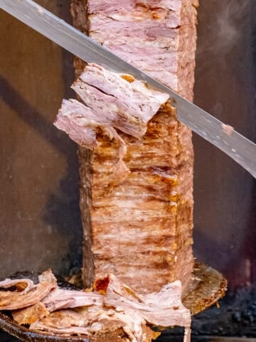 土耳其火鸡正被一把大刀切成薄片放进木勺里。