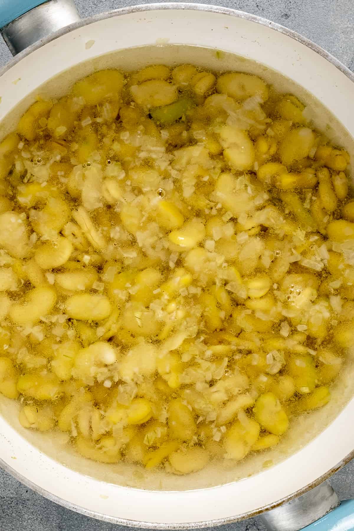 用白色平底锅在热水中煮蚕豆干。