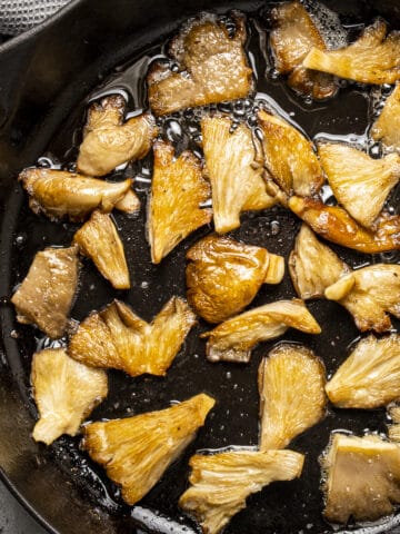 金黄色的平菇在铸铁锅里炒熟。