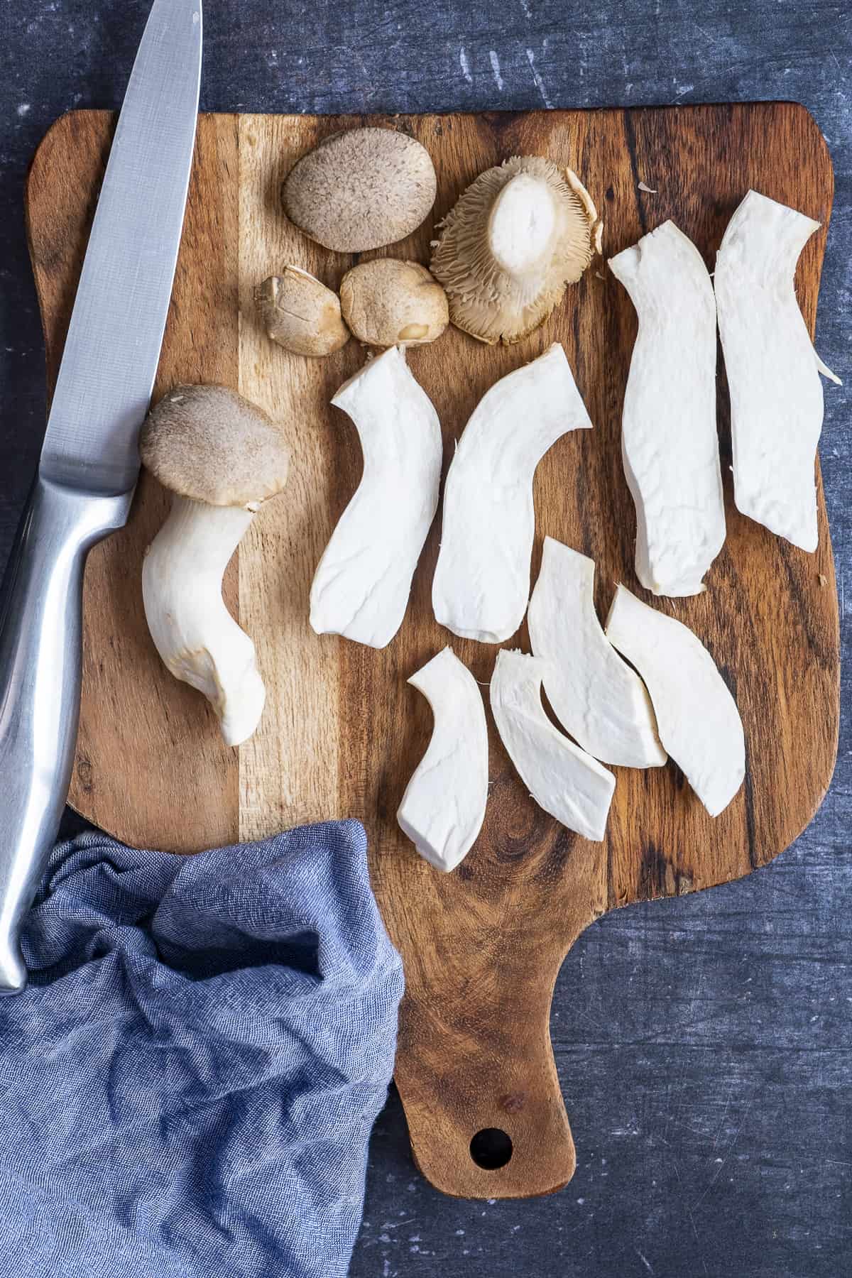 王蚝香菇切在木板上，上面有一把刀。