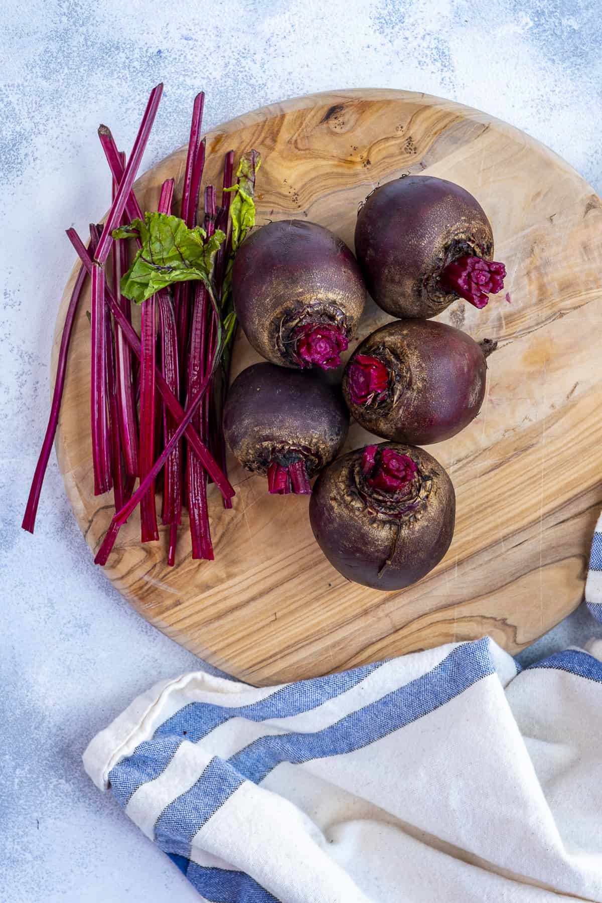 将生甜菜放在木砧板上,并将茎从旁边移走。