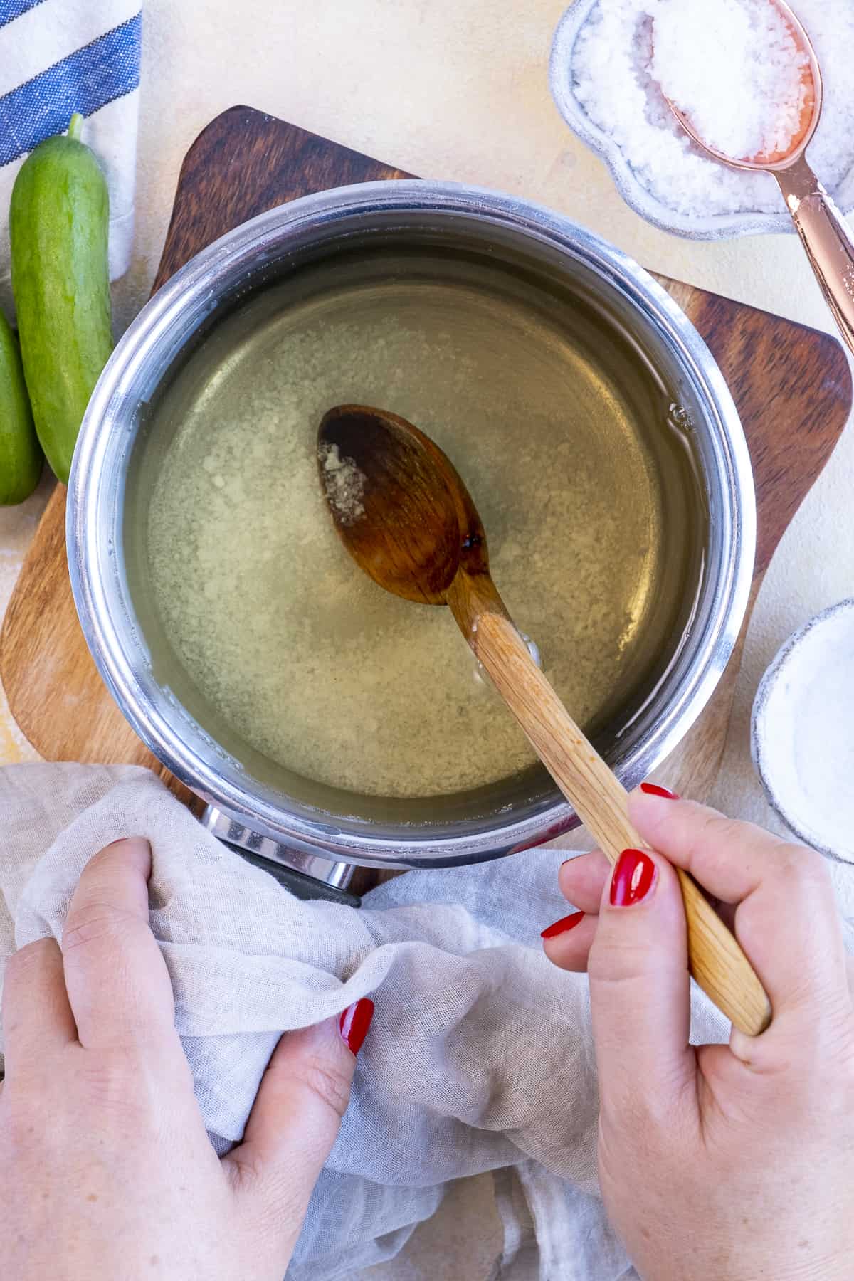 用木勺在平底锅里搅拌腌菜盐水。