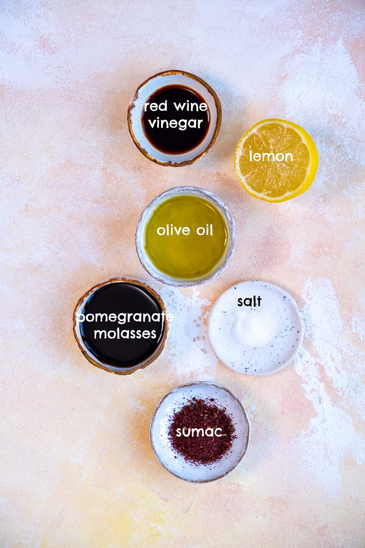 醋，石榴糖浆，柠檬，盐，漆树，橄榄油在浅色背景上。