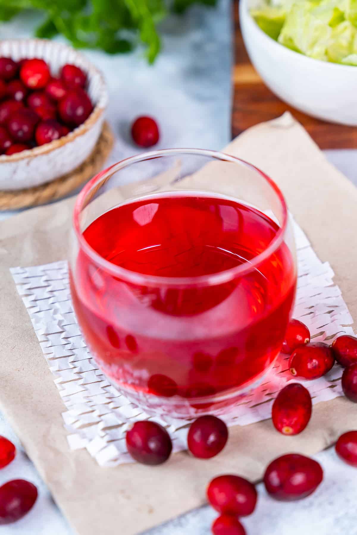 一杯蔓越莓汁和新鲜的蔓越莓。