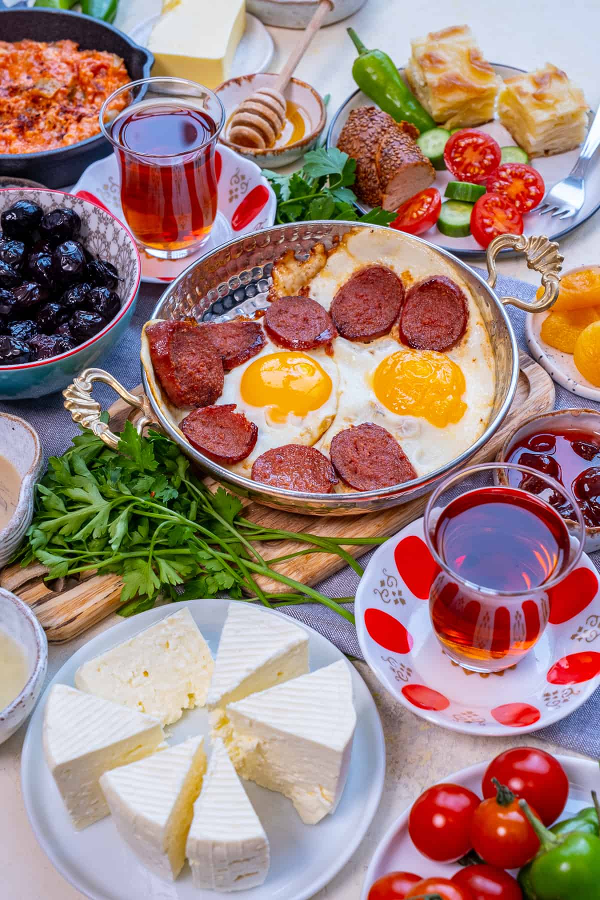 土耳其早餐有鸡蛋和苏juk，橄榄，奶酪和郁金香杯土耳其茶。