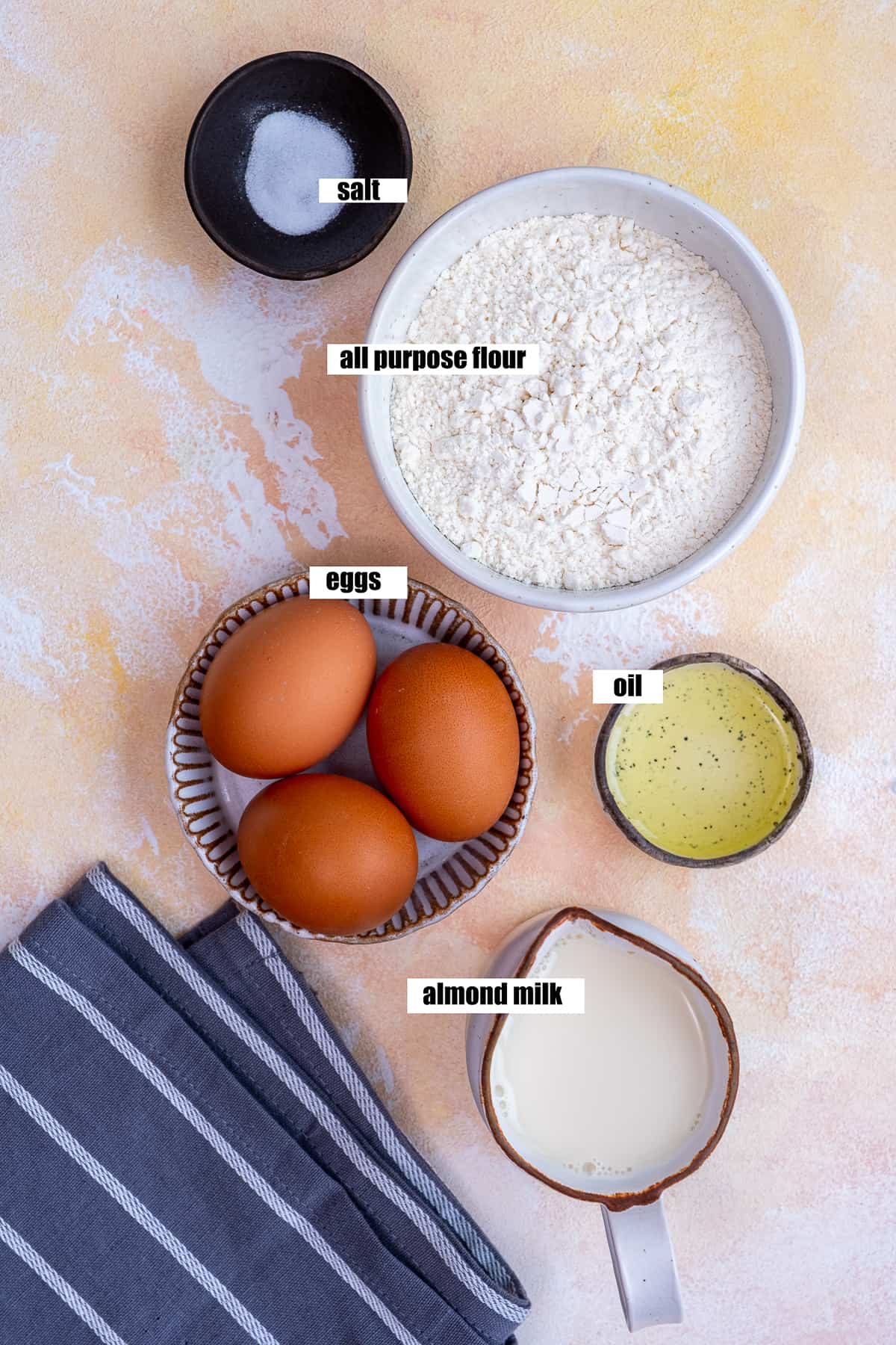 盐，面粉，鸡蛋，油和杏仁奶在浅色的背景上。