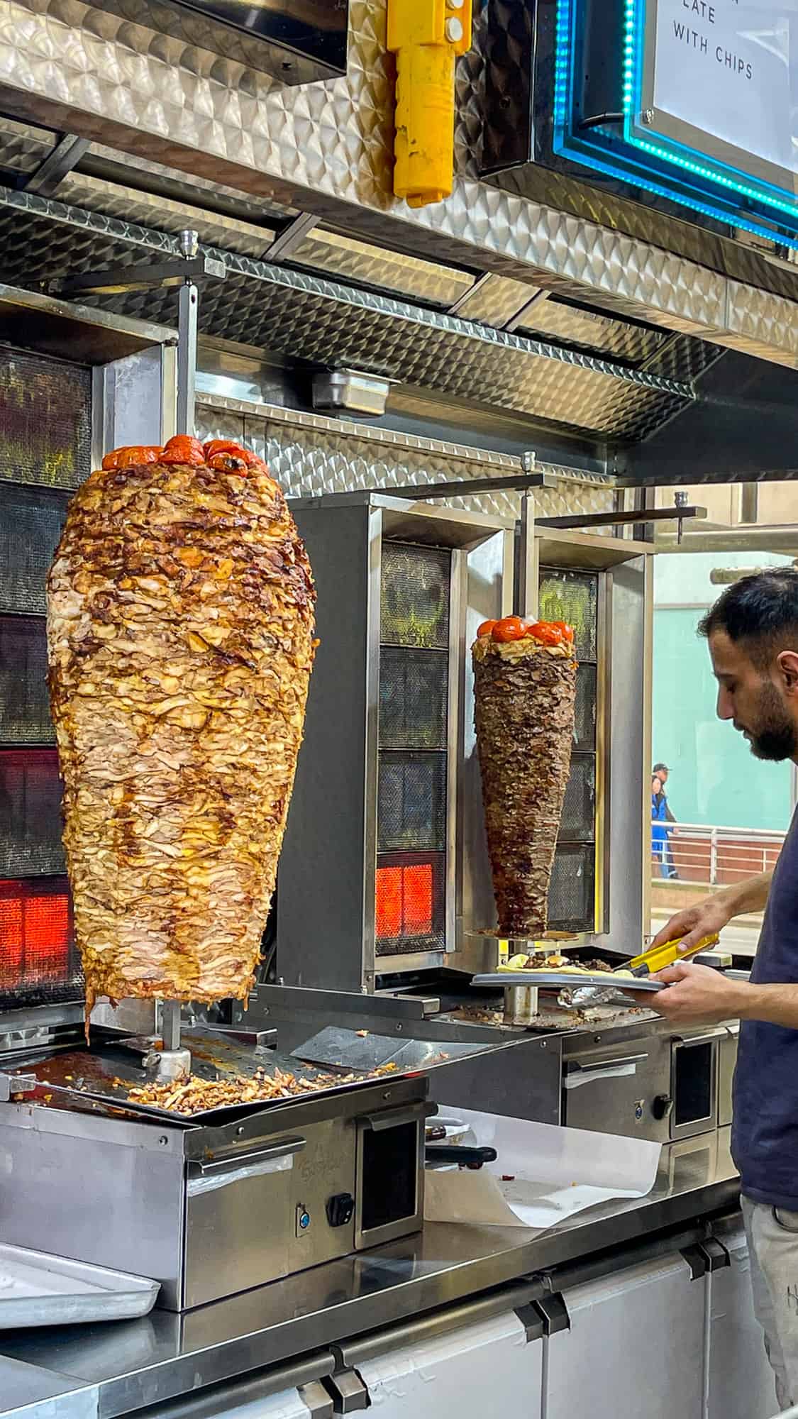 在一家商店里,鸡肉烤肉串和羊肉烤肉串放在垂直的吐槽上。